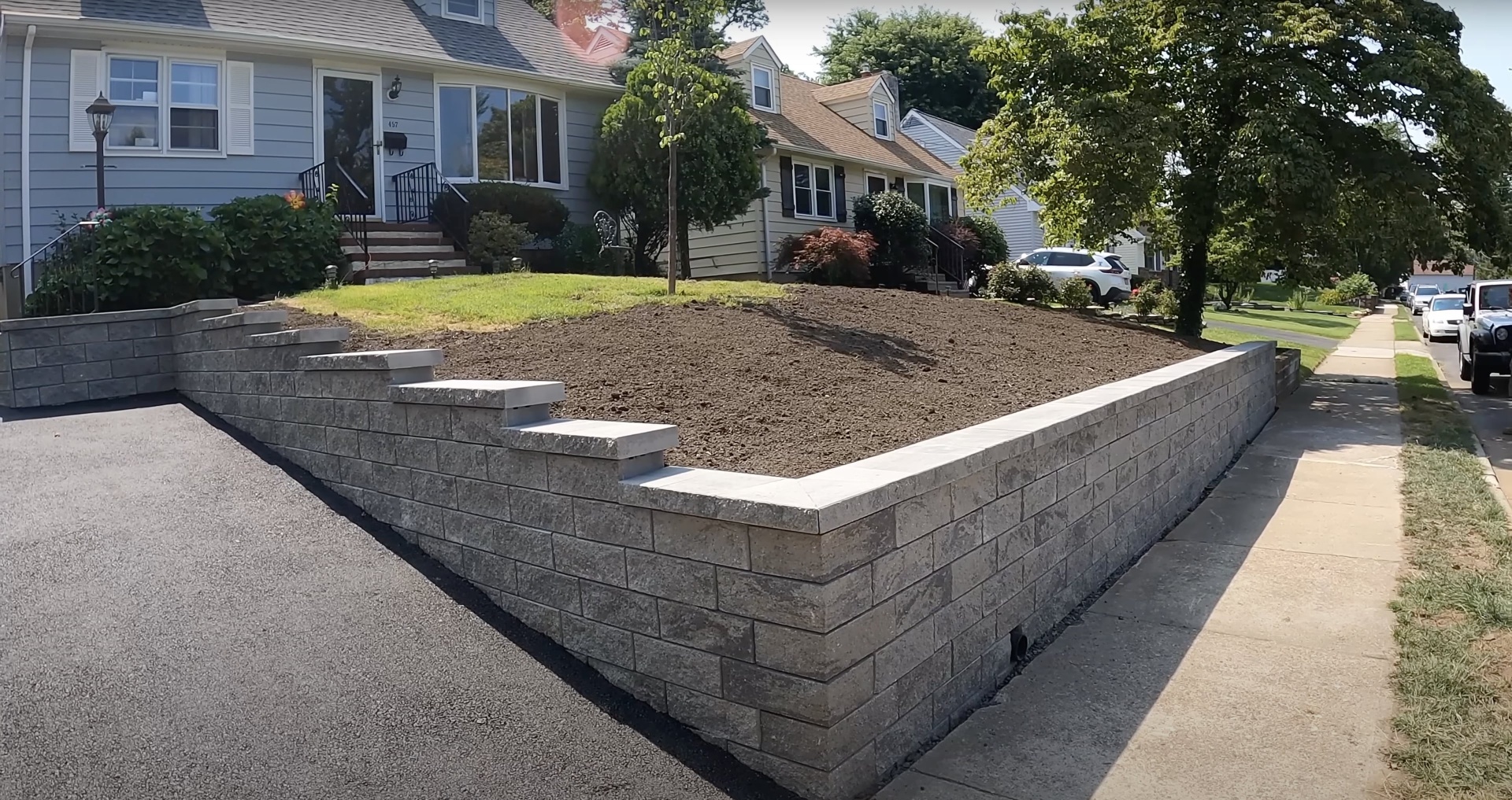 Professional concrete retaining wall construction Completed concrete retaining wall installation in residential setting